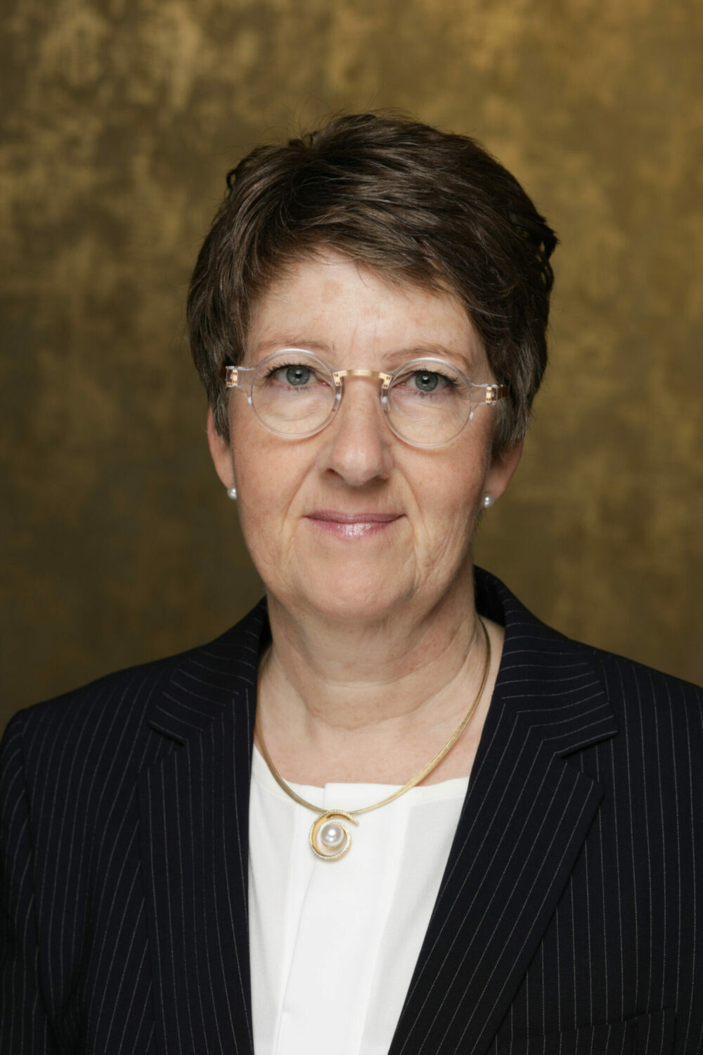 Porträtfoto einer Frau mit dunklen kurzen Haaren und Brille