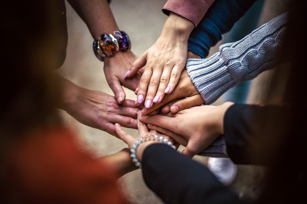 Diverse Menschen stapeln Hände zusammen