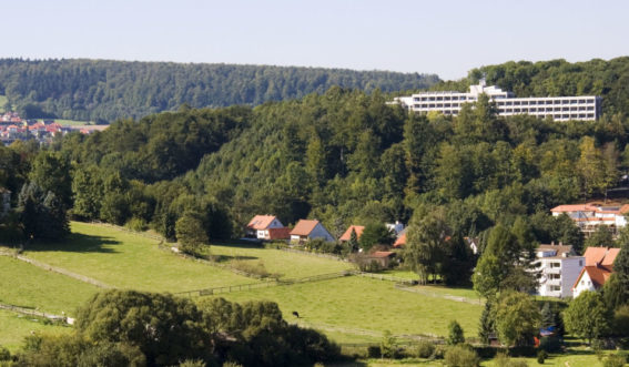 Klinikgebäude am Hang umgeben von Wald