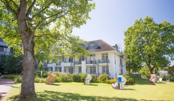 Klinikgebäude mit Strandkörben auf grüner Wiese