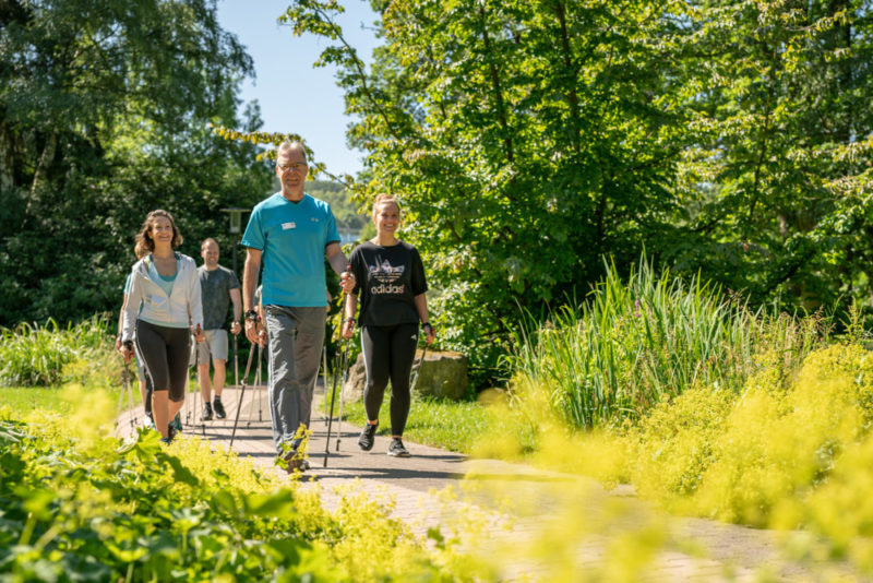 Frauen und Männer beim Nordic Walking im Park