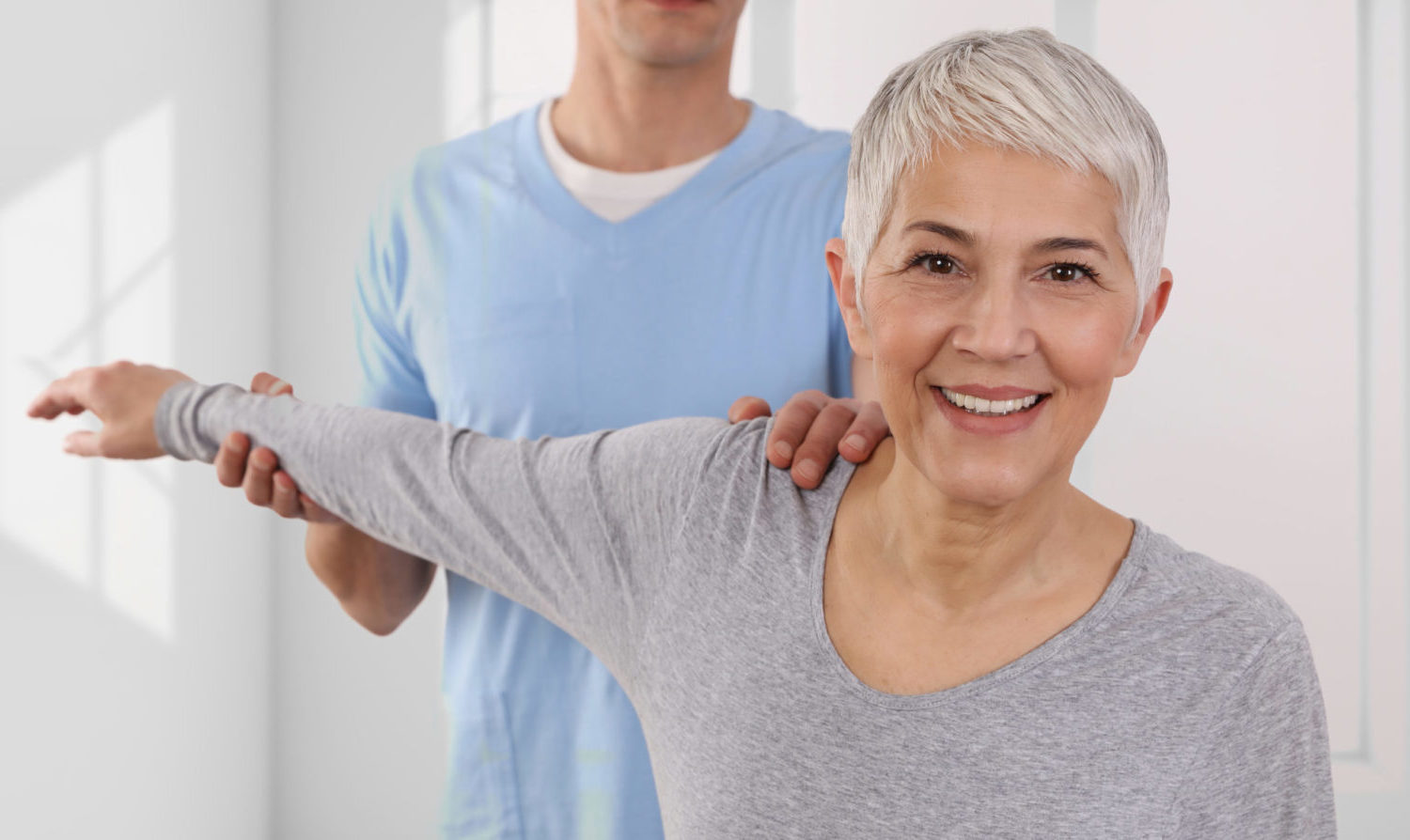 Grauhaarige Patientin während einer chiropraktischen Anwendung